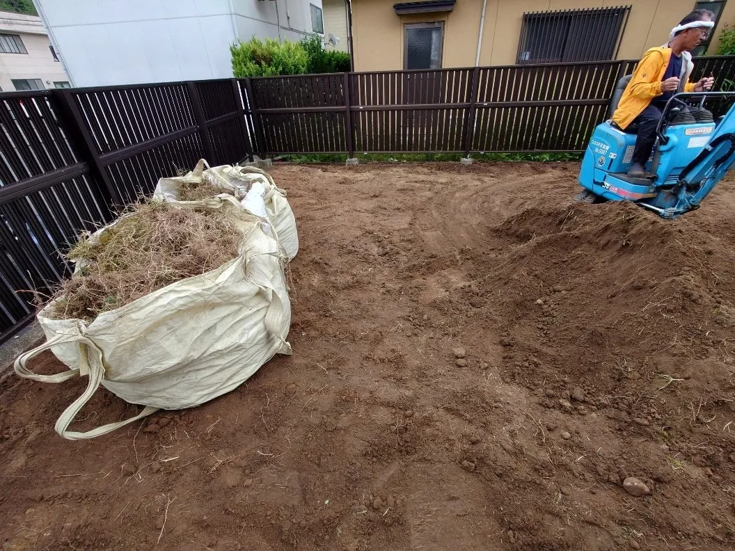 既存の芝、雑草を全て鋤取りし、新たに山砂を入れました。整地し除草剤を噴霧し防草シートの敷き込みです。